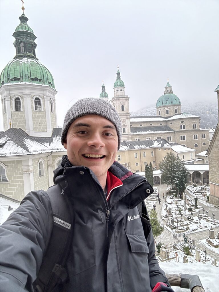 Adin Dowling, Goldwater Scholar, is standing in front of a winter castle.