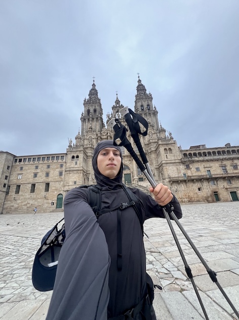 Alexander Ober '26 taking a selfie with hiking poles in front of a historic building