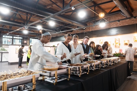 Attendees serve themselves food.